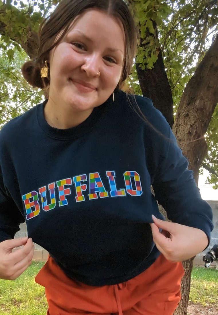 Cassidy smiling in her Buffalo sweatshirt from Golisano Children's Hospital